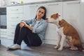 Sad woman sitting on a kitchen floor with her dog Royalty Free Stock Photo