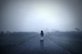 Sad woman standing alone in a misty morning Royalty Free Stock Photo