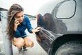 Sad woman standing near car with scratch Royalty Free Stock Photo