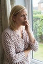 Sad Woman Suffering From Agoraphobia Looking Out Of Window