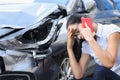 Sad woman talking on cell phone near wrecked car Royalty Free Stock Photo