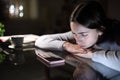 Sad woman waiting for a phone call in the night at home Royalty Free Stock Photo