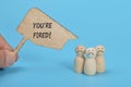 sad wooden figure of people with text YOU\'RE FIRED