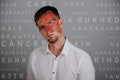 sad worried indifferent man with a sunburned face. With background made of skin care captions Royalty Free Stock Photo
