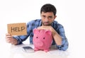 Sad worried man in stress with piggy bank in bad financial situation Royalty Free Stock Photo