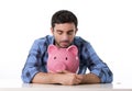 Sad worried man in stress with piggy bank in bad financial situation Royalty Free Stock Photo
