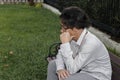 Sad and worried young Asian man sitting on bench  suffering from severe depression. Failure and layoff concept Royalty Free Stock Photo