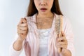 Sad young Asian girl looking at her hair loss with shock isolated on white background Royalty Free Stock Photo