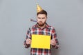 Sad young bearded birthday man holding copyspace board