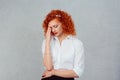 Sad young beautiful woman with worried stressed face expression looking down hand on face isolated gray background Royalty Free Stock Photo