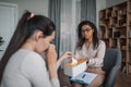 Sad young black lady psychologist consulting crying european woman in clinic interior, doctor calm client in grief Royalty Free Stock Photo