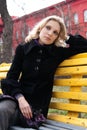 Sad young blonde sitting on a bench in the park Royalty Free Stock Photo