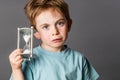 Sad young boy with big blue eyes holding egg timer Royalty Free Stock Photo