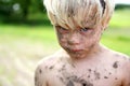 Sad Young Boy Covered in Dirt and Mud Outside Royalty Free Stock Photo