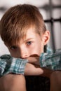 Sad Young Boy with Knees Up Looking at the Camera Royalty Free Stock Photo