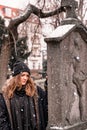 sad young brunette woman standing on snowy day next to grave Royalty Free Stock Photo