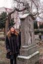 Sad young brunette woman standing on snowy day next to grave Royalty Free Stock Photo