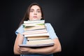 Sad college student carrying a stack of books Royalty Free Stock Photo