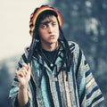 Sad young fashion hipster man in rasta hat and poncho Royalty Free Stock Photo