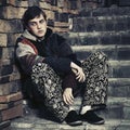 Sad young fashion hipster man sitting on the steps Royalty Free Stock Photo