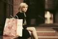 Sad young woman with shopping bags sitting on mall steps Royalty Free Stock Photo