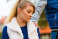 Sad young girl sit outdoors with friend.