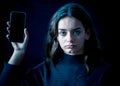 Sad young girl with smartphone suffering harassment online. Onli Royalty Free Stock Photo