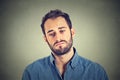 Sad young man on gray wall background