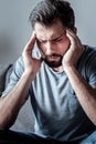 Sad young man holding his temples Royalty Free Stock Photo