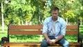 Sad young man sitting alone park bench, breakup crisis, problem hopelessness Royalty Free Stock Photo