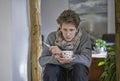 Sad young sick man with a thermometer and a cup of tea in his hands Royalty Free Stock Photo