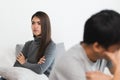 Sad young wife sitting on the bed back to back from husband after argument Royalty Free Stock Photo