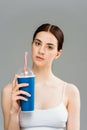 Sad young woman with acne on face holding plastic cup Royalty Free Stock Photo