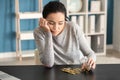 Sad young woman counting coins at table Royalty Free Stock Photo