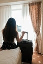 Sad young woman with luggage ready to leave the hotel room. Last day of vacation. Time to go back home. Short trip during Royalty Free Stock Photo