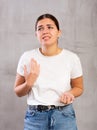 Sad young woman posing crossly against gray background Royalty Free Stock Photo