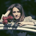 Sad young fashion woman with red roses outdoor Royalty Free Stock Photo