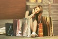 Young woman with shopping bags sitting on sidewalk Royalty Free Stock Photo