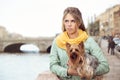 Sad young woman with small dog on the embarkment, waiting friend. Royalty Free Stock Photo