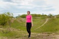 Sad young woman in sportswear standing on hill. Fitness, healthy way of life, wellbeing, freedom, mental health, working off stres Royalty Free Stock Photo