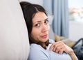 Sad young woman thinking on sofa in home interior Royalty Free Stock Photo