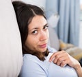 Sad young woman thinking on sofa in home interior Royalty Free Stock Photo