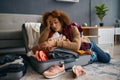 Sad young woman and unpacked vacation luggage Royalty Free Stock Photo