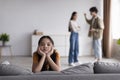 Sad youngsters girl looks at camera, young asian couple quarreling at home in living room interior Royalty Free Stock Photo