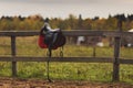 A saddle hangs on a wooden fence Royalty Free Stock Photo