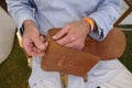 Saddler. Leather craftsman at work. He  sews a bag by hand. Close-up. Royalty Free Stock Photo