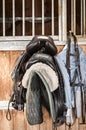 Saddles in front of stable door Royalty Free Stock Photo