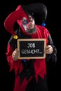 Sadly clown holding a slate with german text job wanted, concept Royalty Free Stock Photo