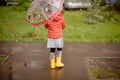 sadness cute baby girl in the rain runs through the puddles Royalty Free Stock Photo