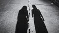 Sadness and grief, A couples shadows separated on the pavement by a craving. Royalty Free Stock Photo